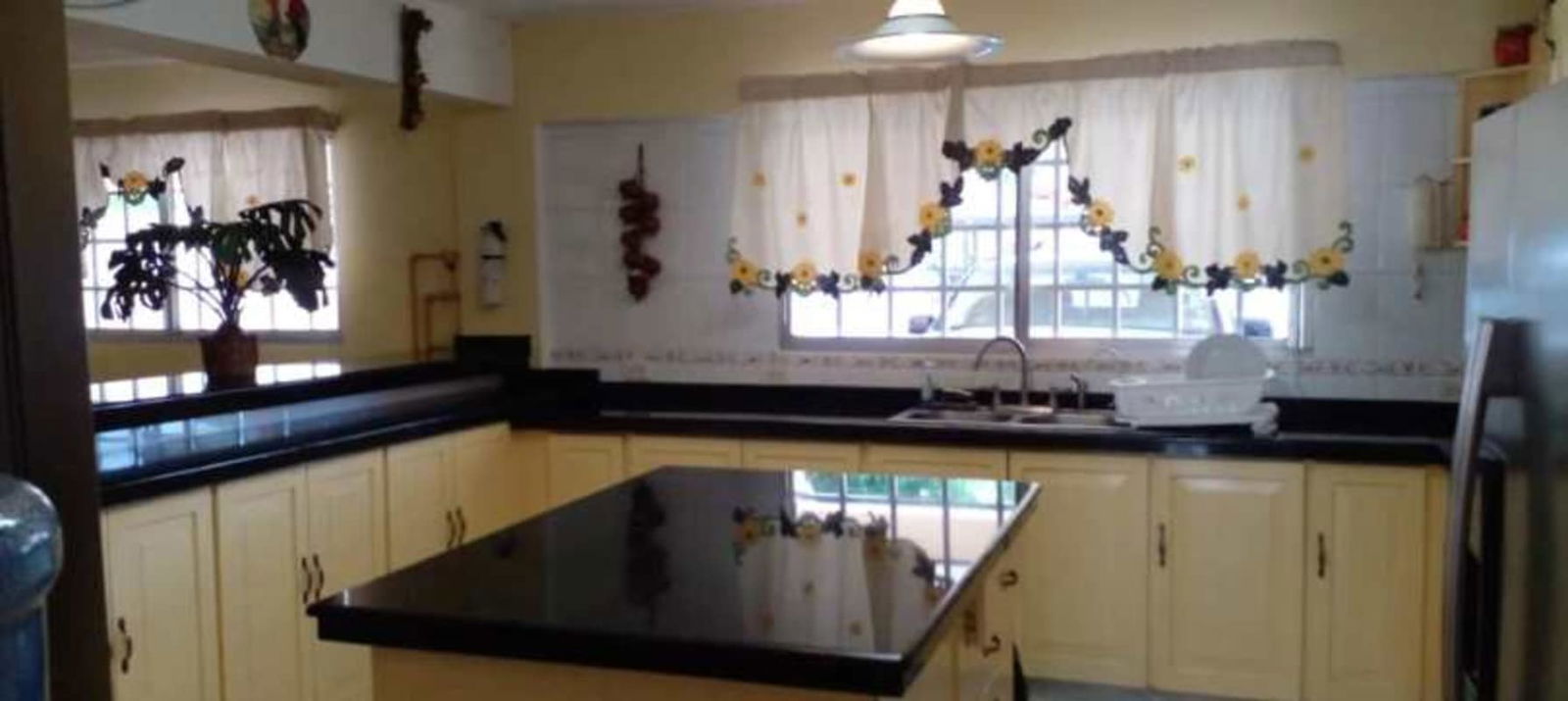 Interior landing with wooden staircase, chandelier, louvered closets in Miraflores Panama house