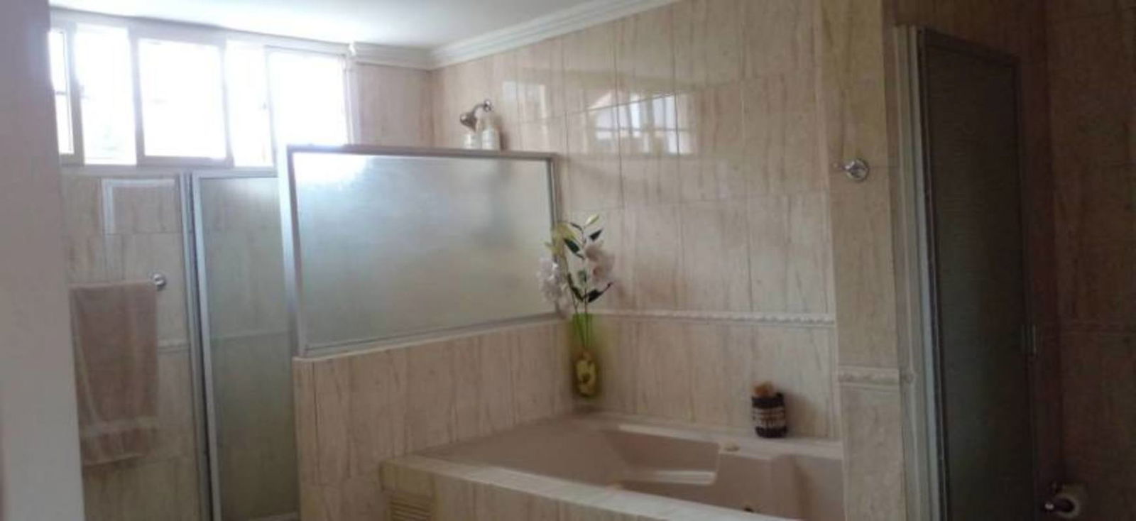 Bathroom with separate bathtub, glass enclosure shower, tile walls in Miraflores Panama