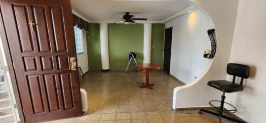 Spacious indoor patio area with sliding doors, green wall and tiled floors in beach home for sale Panama
