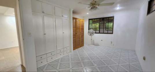 Bedroom with built-in closet, shelves, and tile floor in Santa Clara house for sale