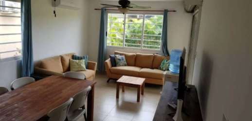 Open plan living dining space with AC, large windows, beige sofas in Coronado Panama