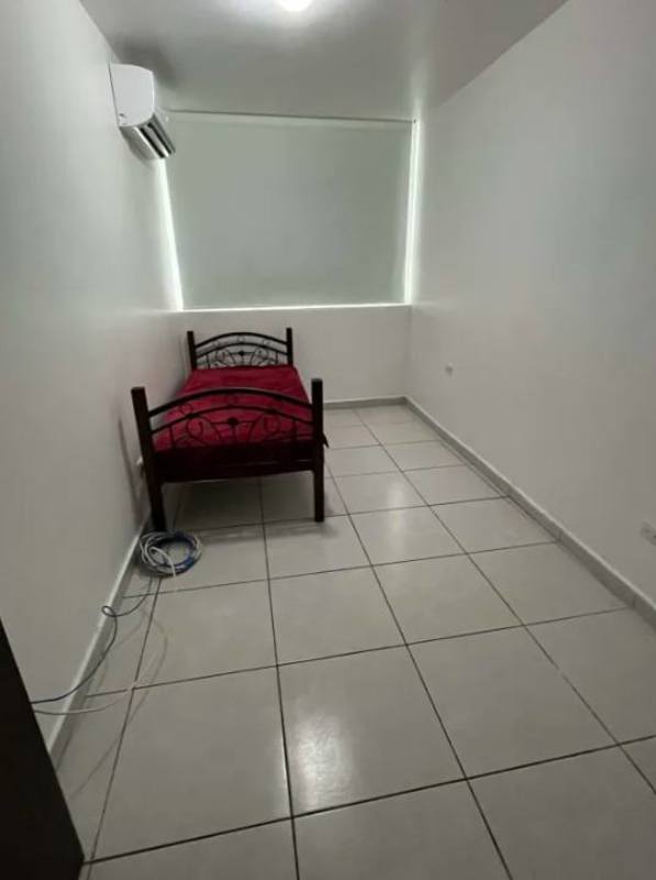 Minimalist bedroom with single bed, split AC unit, window blinds, tiled floors PH Luxor Towers Obarrio Panama