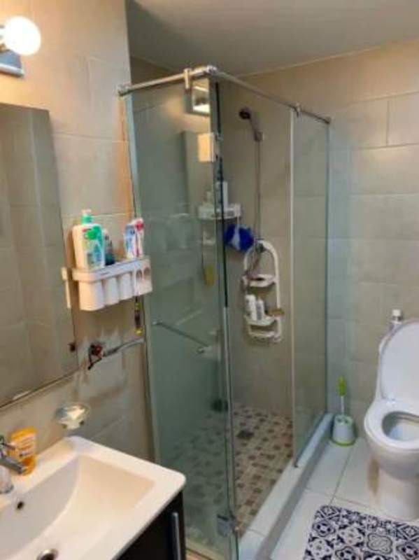 Modern bathroom with glass enclosed shower, wall-mounted sink, and mosaic tiles in PH Luxor Towers Obarrio Panama