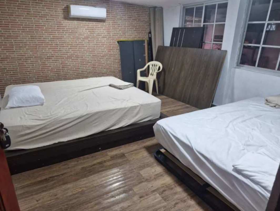 Living area with large windows and hammock, rustic decor, sliding glass doors to garden in mountain retreat Panama