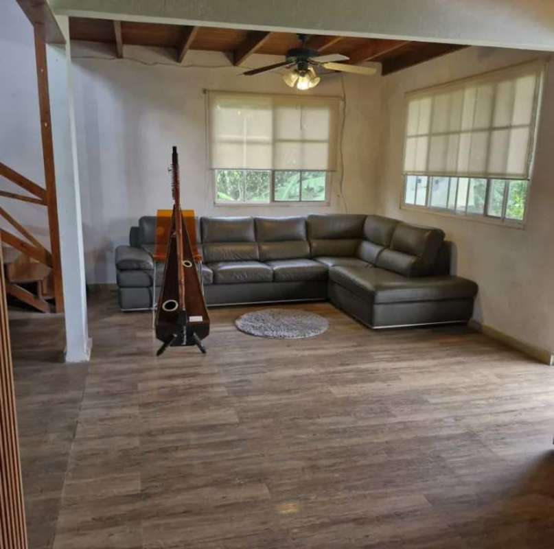 Rustic bedroom with wood panel accent wall, wooden ceiling, metal frame bed in Altos de Cerro Azul mountain retreat