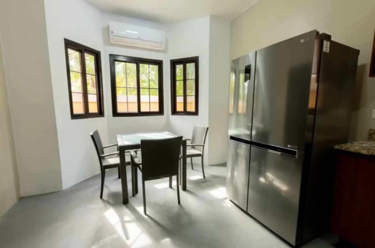 Kitchen with glass dining table and stainless refrigerator in Costa Sur house Panama