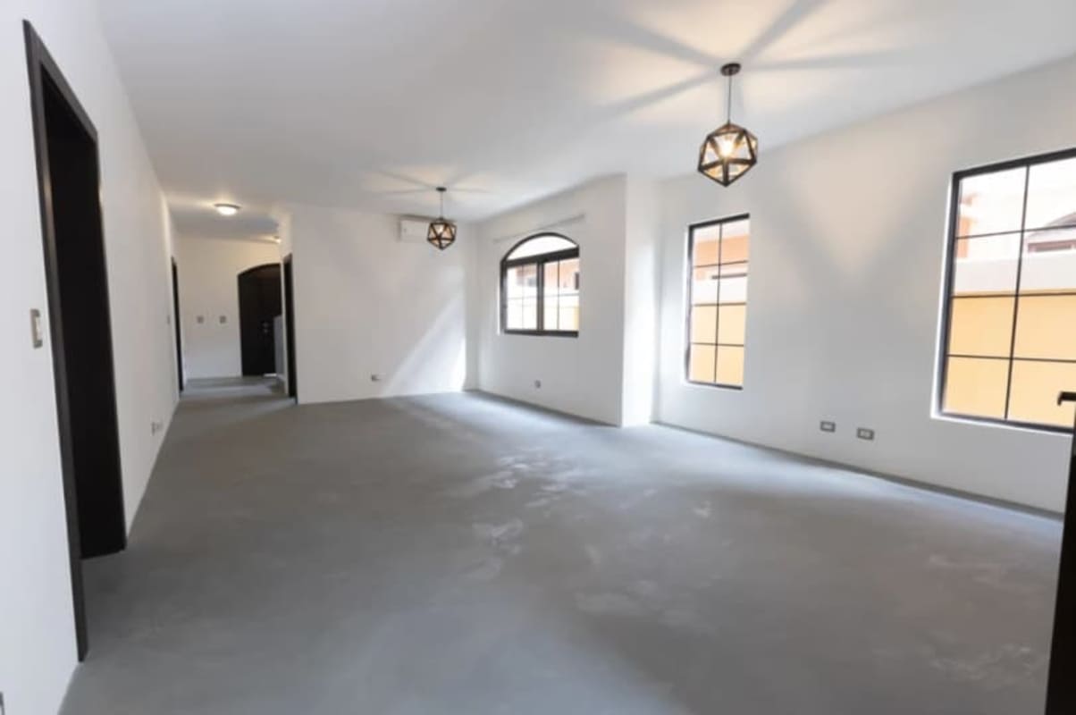 Open space living area with large windows and geometric lighting in Costa Sur residence