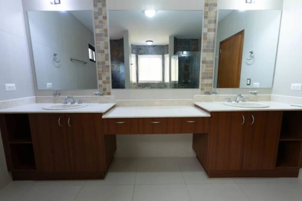 Luxury bathroom with double sinks and mosaic accents in Costa Sur home Panama