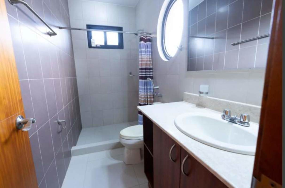 Modern bathroom with walk-in shower, window and vanity Costa Sur house Panama