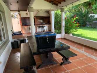 Covered outdoor BBQ kitchen with brick grill, sink, tile, metal cabinets Coronado beach house for sale Panama