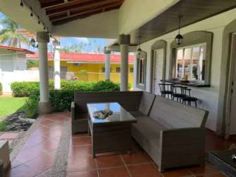 Traditional kitchen with blue tiled backsplash, wooden cabinets, island table at Coronado beach house Panama