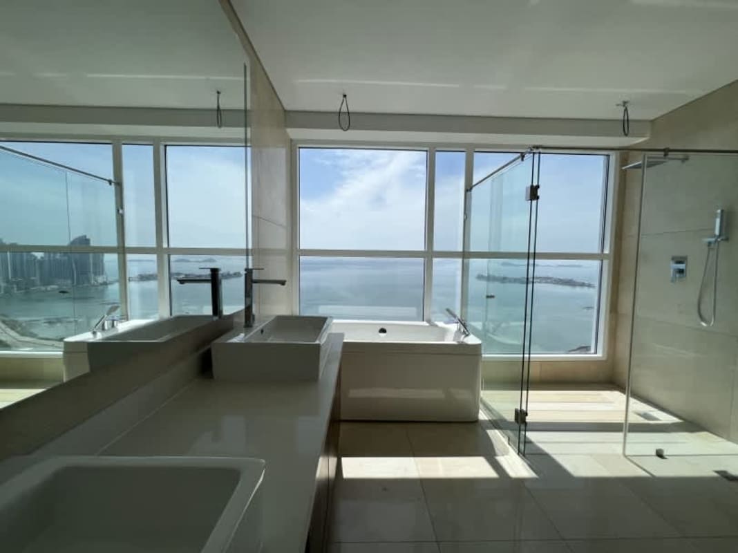 Modern master bathroom with bathtub and large windows facing ocean in PH Windrose penthouse