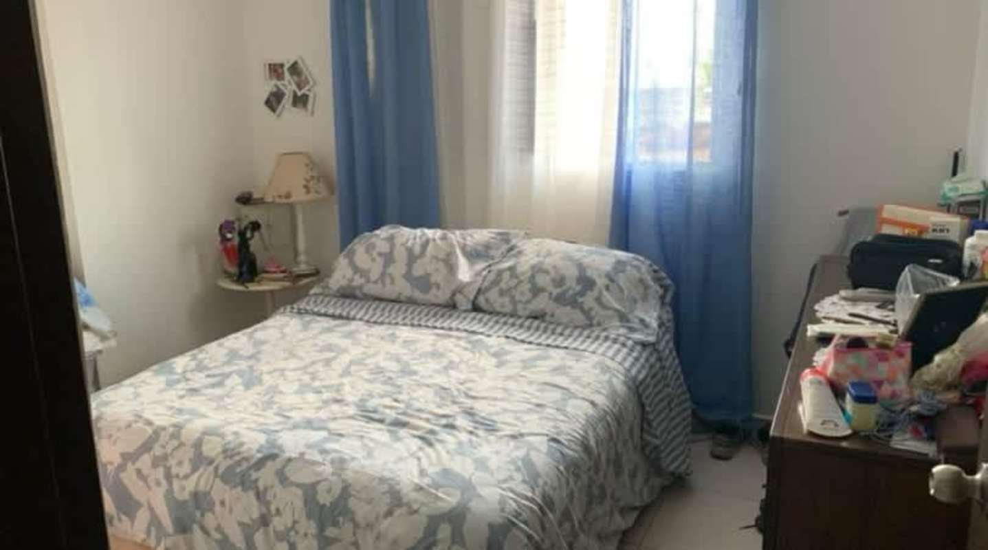 Bedroom with blue curtains, double bed and lamp in PH Lomas de Santa María Panama City