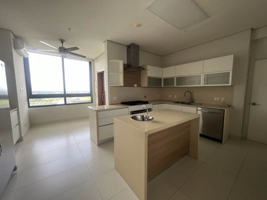 Modern kitchen with island, white cabinets, stainless appliances and golf view in luxury apartment for rent in Santa Maria Panama City