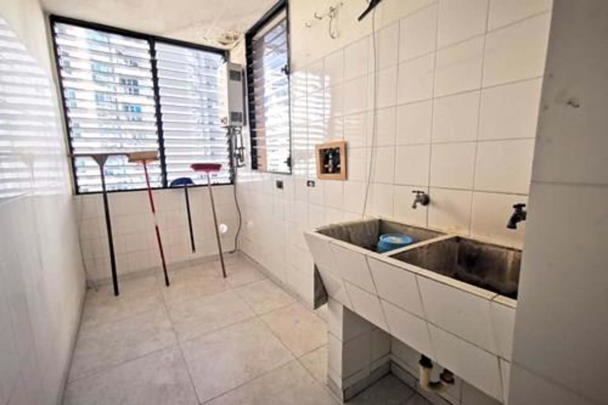 Modern kitchen with black granite countertops, central island and ample storage in PH Costa del Mar Panama