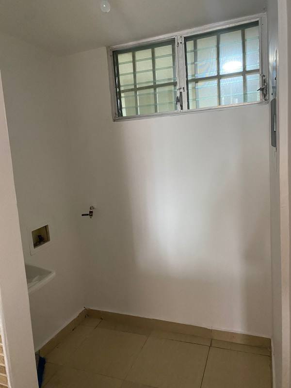 Laundry area with ceramic tiles, utility sink and bright window in PH Carrasquilla Urban Center Panama City