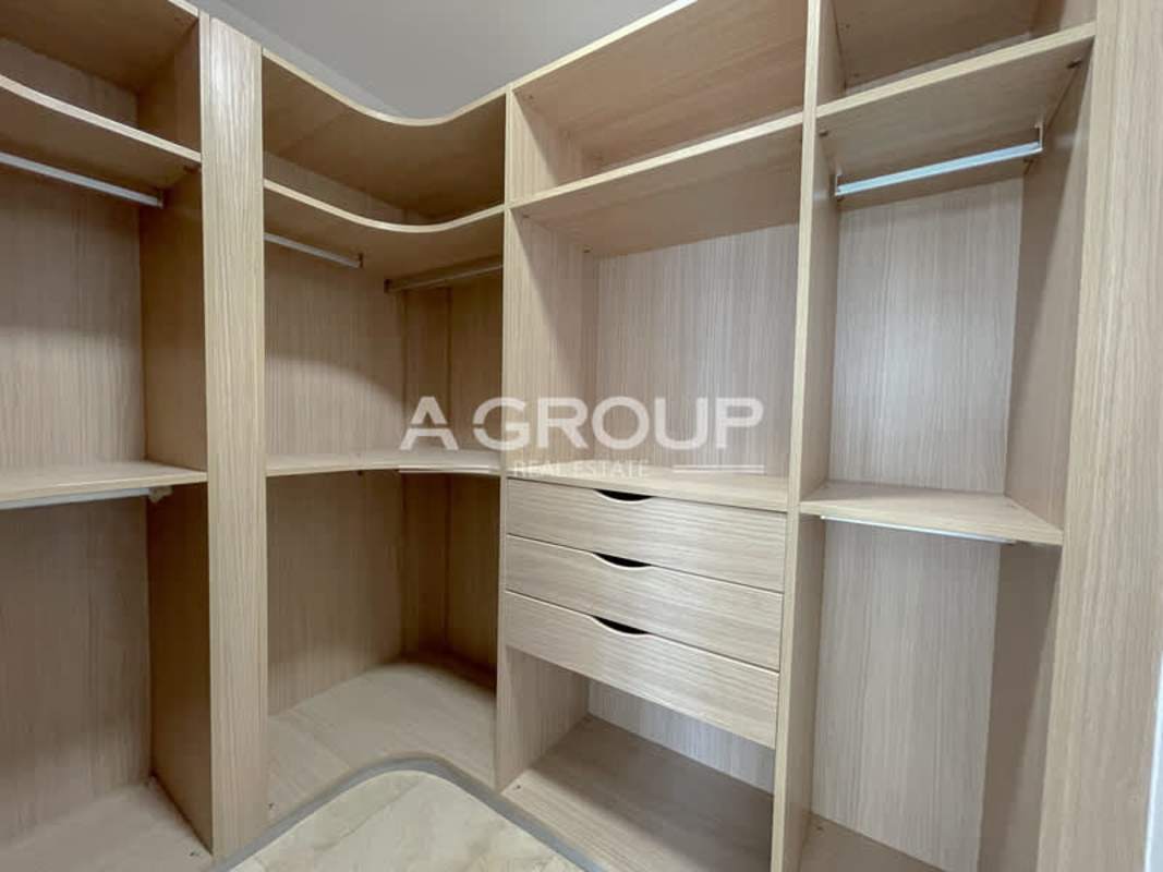 Spacious walk-in closet with built-in shelves and drawers in luxury condo Aventura Tower Punta Paitilla Panama