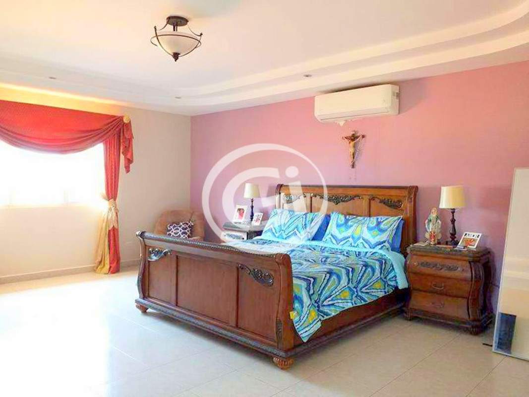 Girl's child bedroom with pink walls, bright curtains, crib and toys in Residencial El Doral house Panama