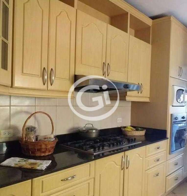 Kitchen with wood cabinets, black granite countertops, and modern appliances at El Doral Panama