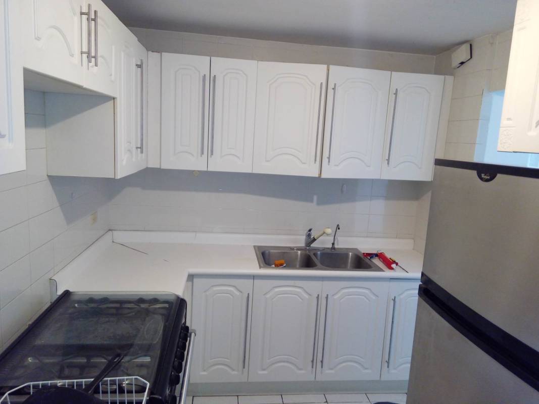 Kitchen with white cabinets, gas stove, double sink in PH Park View II El Dorado Panama