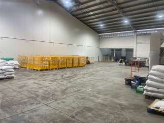 Large open warehouse interior with stacked pallets and industrial lighting Aguadulce Coclé Panama