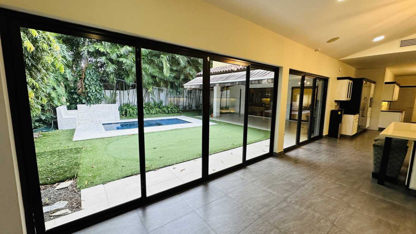 Modern interior staircase with marble steps, glass railing, chandelier in luxury house Costa del Este Panama