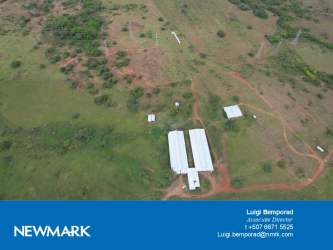 Aerial showing large pasture farmland and white barns at cattle ranch La Mesa Panama