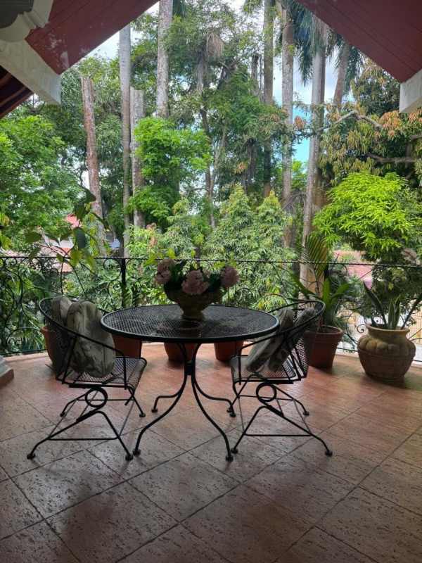 Balcony with wrought iron furniture and lush garden view in Clayton Albrook Panama