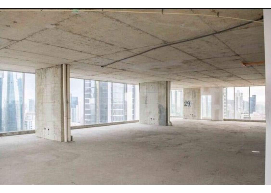Corner open plan commercial space with concrete floors and large windows in Torre Optima Obarrio Panama