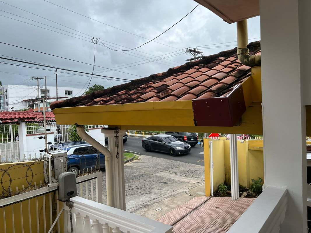 Yellow facade home with tiled roof, gated fence on Avenida 12 de Octubre mixed residential-commercial Panama City
