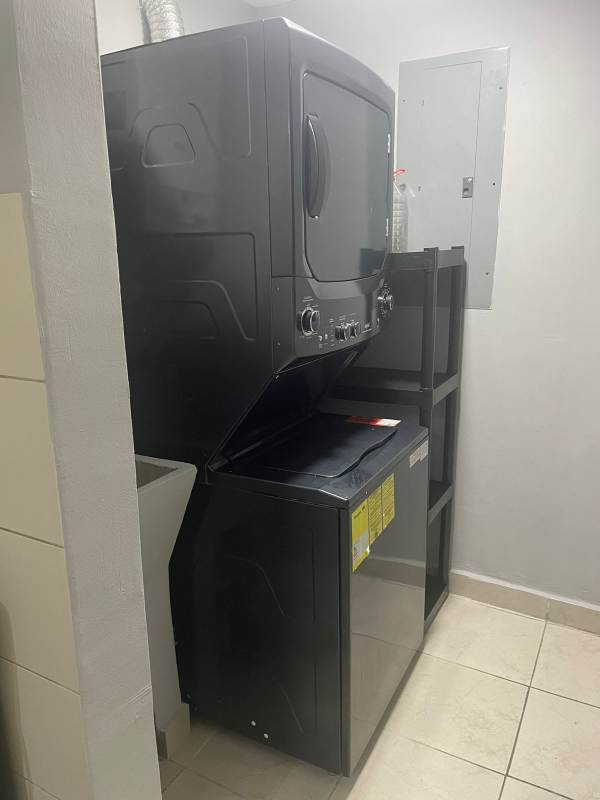 Laundry room with washer dryer center and shelves in PH Vista Marina Towers apartment Panama