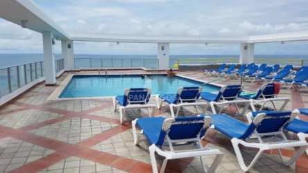 Ground floor beachfront infinity pool with sun loungers at PH Coronado Bay in Coronado Panama