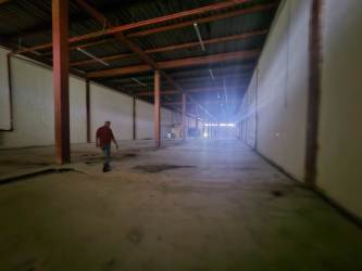 Expansive interior warehouse space with high ceilings and concrete floors in Cocosolito