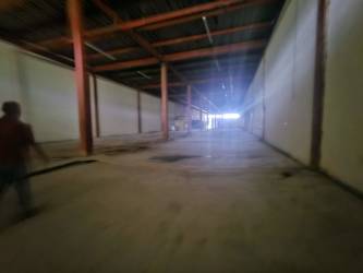 Entrance area of industrial warehouse with rolling metal doors and parking area in Colón Free Zone