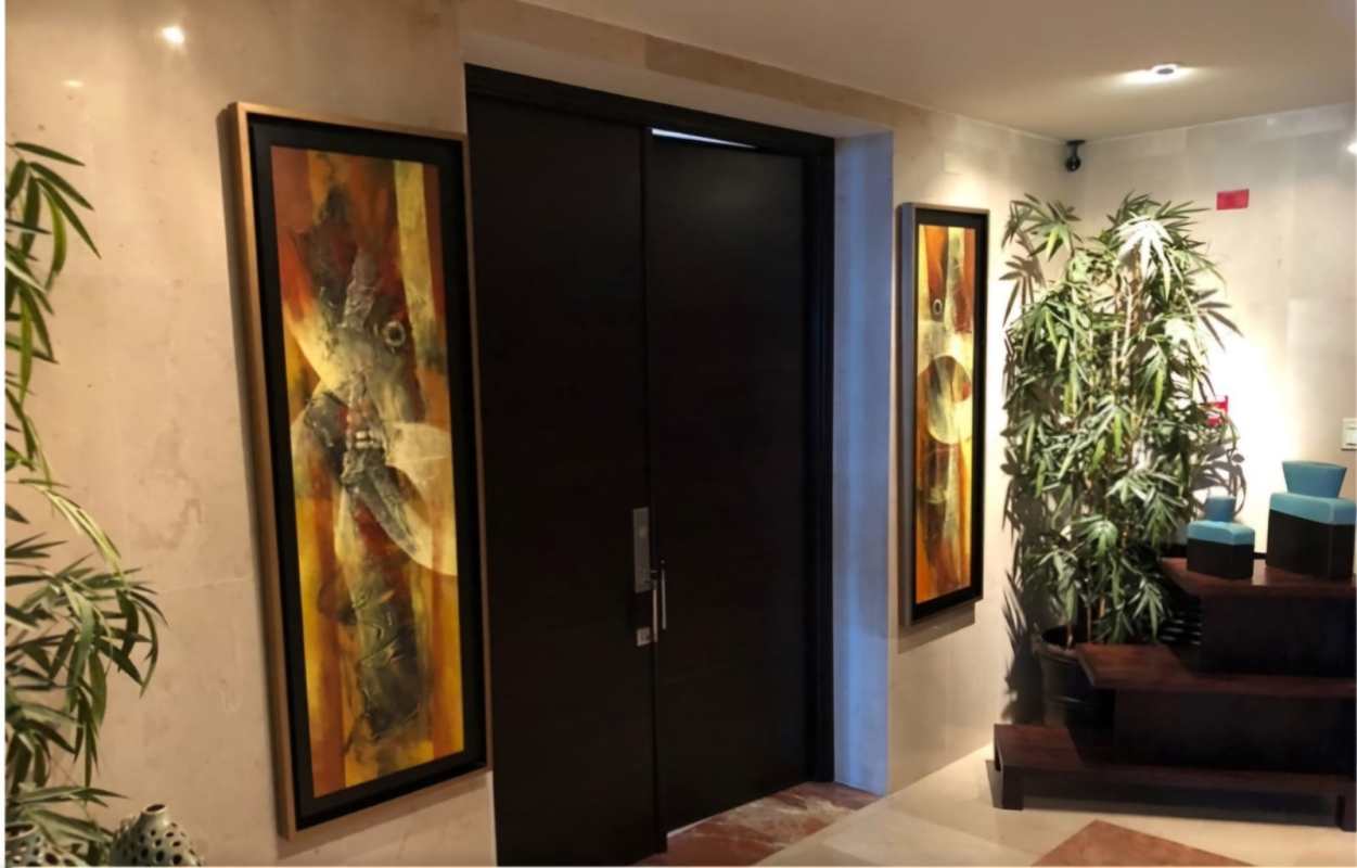 Entry hallway with marble floors, framed gallery wall art and floral decor PH Torre Zeus Panama