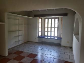 Living room with large windows, built-in shelving, window seat in beach house Coronado Panama