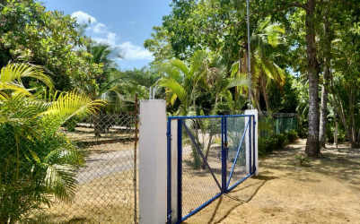 Gated entrance with blue metal gate and tropical landscaping Coronado rental Panama
