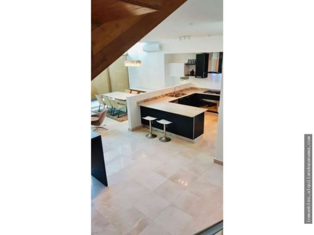 Loft kitchen with island, black cabinets, stainless steel appliances, wood accents PH Pacific Village Punta Pacifica Panama