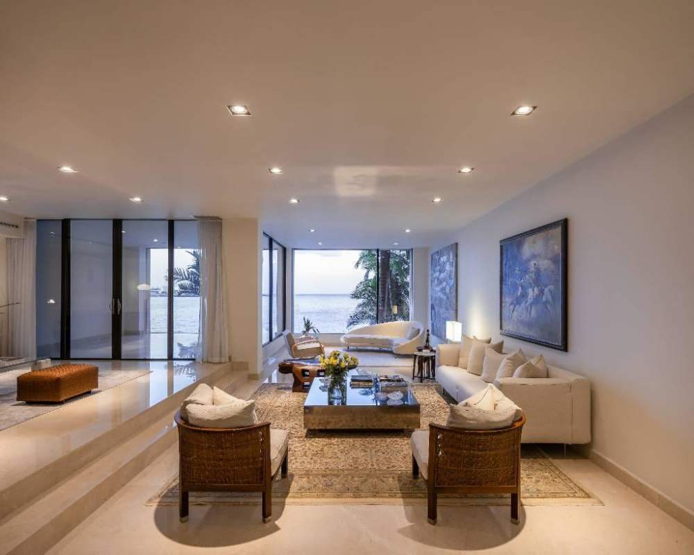 Modern coastal living room with floor-to-ceiling glass, ocean views, elegant furnishings in Punta Paitilla luxury villa