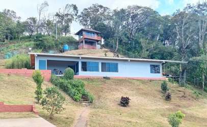 Single-story residence on hillside with small view tower overlooking countryside