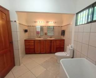 Large bathroom with double sinks, bathtub, tile walls in country estate Boquete