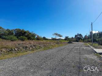 Open flat lot along paved road with mountain backgrounds for sale in Alto Boquete Panama