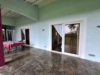 Open plan coastal living room with windows and access to terrace Portobelo Panama