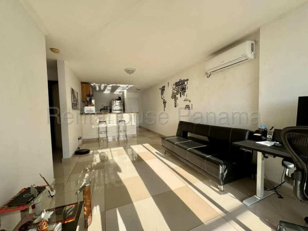 Spacious living room with glass doors leading to balcony in PH Torres de Vista Hermosa Panama