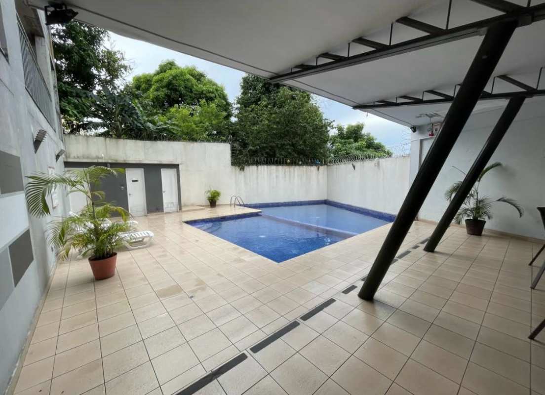 Compact laundry area with washer dryer stack, wall heater window in Panama apartment
