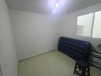 Bedroom with tiled floor, plain white walls, and window in Los Cerezos Cluster house