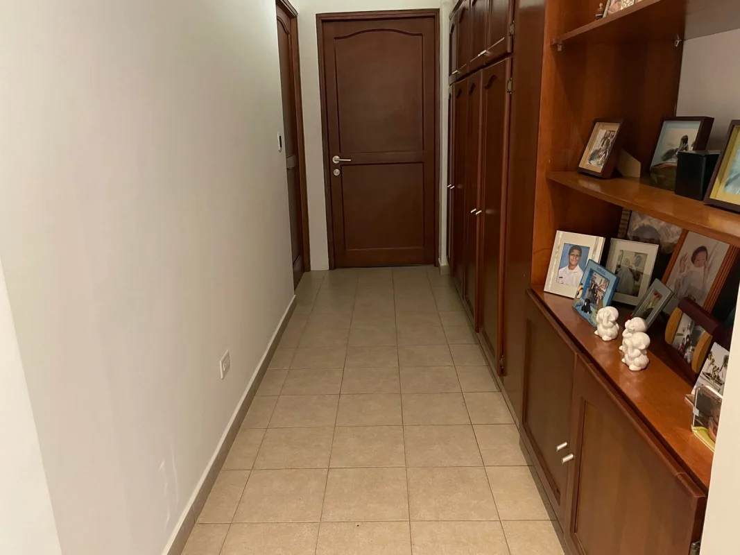 Interior hallway with wood cabinets and decorative shelving in PH Quentino penthouse Panama City