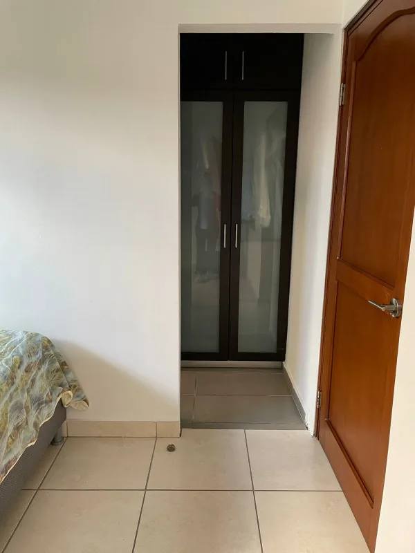 Private bedroom with exposed brick wall and city view window in penthouse PH Quentino Panama