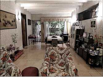 Traditional open living dining room with ceiling beams floral seating Carrasquilla house