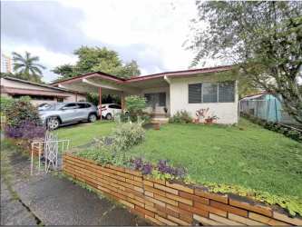 Single story suburban house with carport, large front lawn and brick wall in Carrasquilla Panama